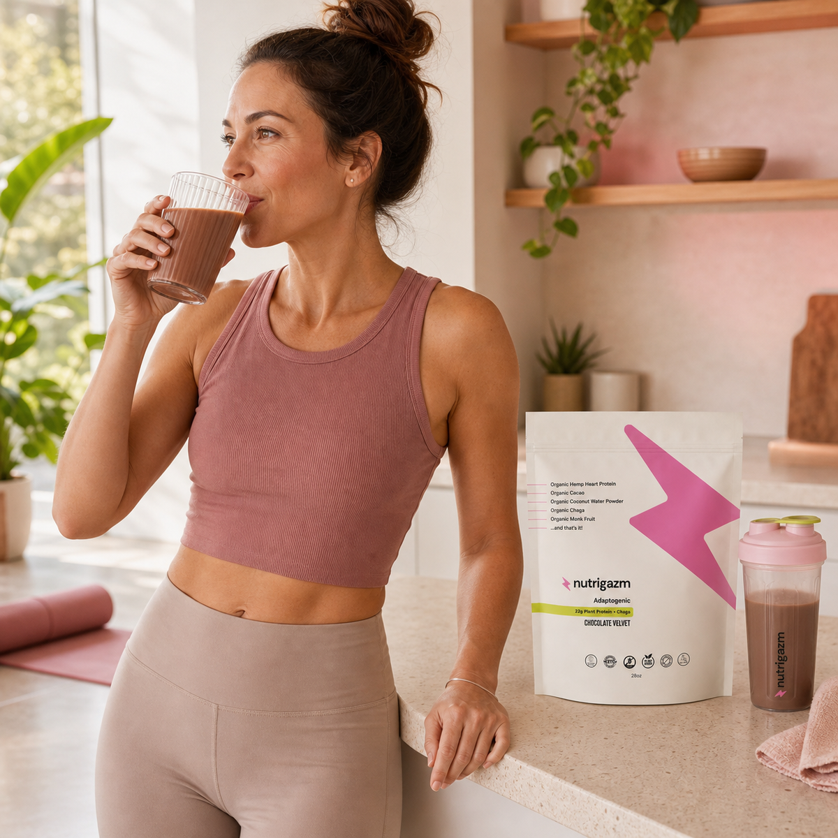 Woman enjoying a Chocolate Velvet shake after a morning movement routine beside the full-size pouch