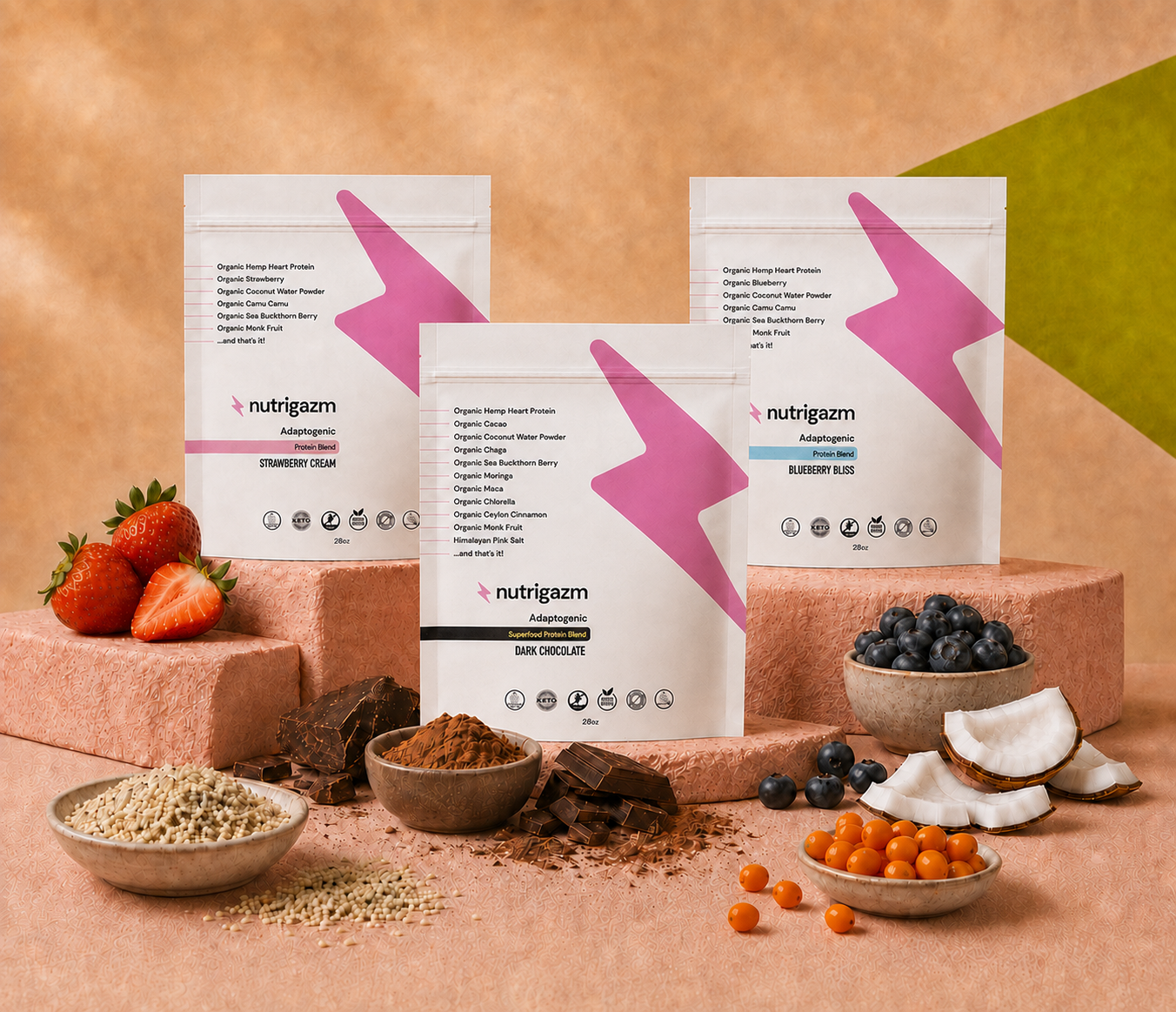 Nutrigazm Strawberry Cream, Blueberry Bliss, and Dark Chocolate pouches surrounded by strawberries, blueberries, cacao, hemp hearts, coconut, and sea buckthorn.